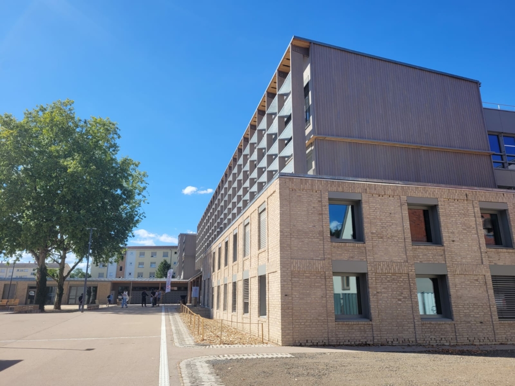 Façade du rez-de-chaussée du collège Agnès Acker Strasbourg en briques ré-utilisées pour le mur